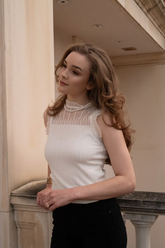 a lady in a white lace top and a pair of black pants
